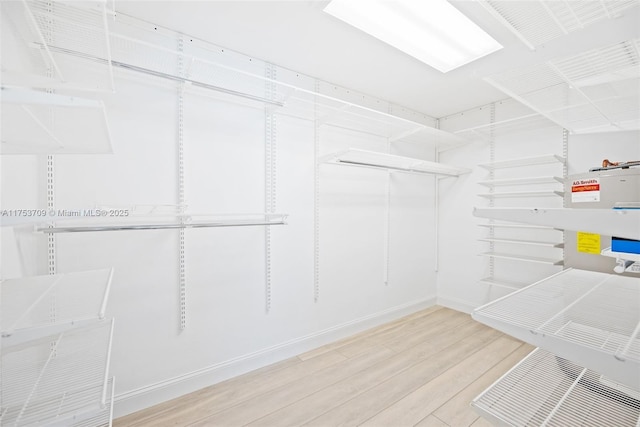 walk in closet with wood finished floors