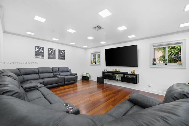 living room featuring visible vents, baseboards, and wood finished floors