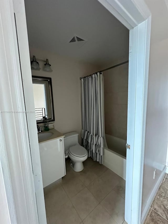 bathroom featuring tile patterned flooring, toilet, shower / tub combo, visible vents, and vanity