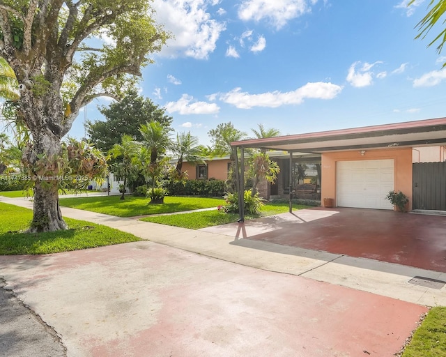 view of front facade with a front yard, driveway, an attached garage, and stucco siding