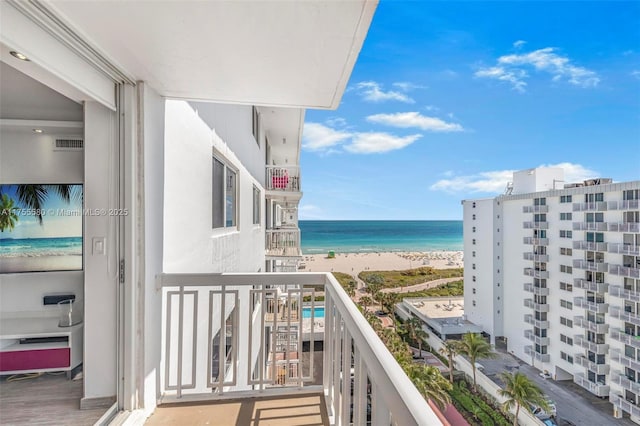 balcony featuring a view of the beach and a water view