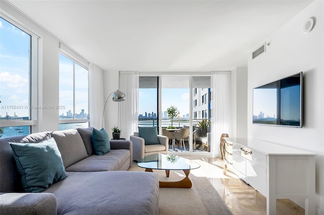 living area with visible vents, a wall of windows, and a city view