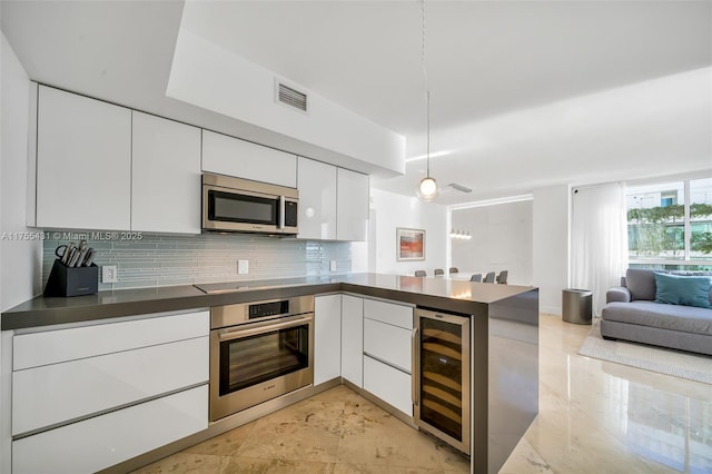 kitchen featuring beverage cooler, visible vents, open floor plan, appliances with stainless steel finishes, and dark countertops