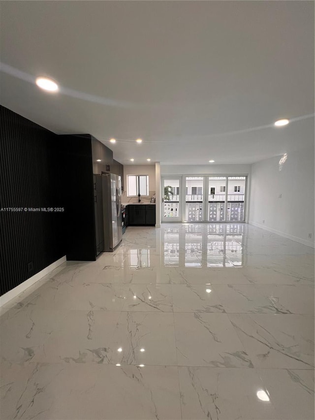 unfurnished living room with marble finish floor and recessed lighting