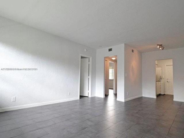 empty room featuring baseboards and visible vents