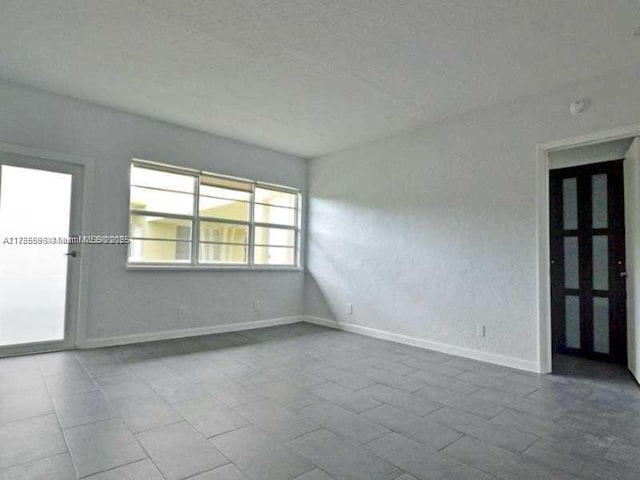 unfurnished room featuring baseboards