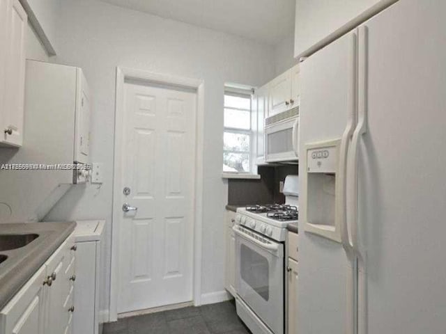 kitchen with light countertops, white appliances, and white cabinets