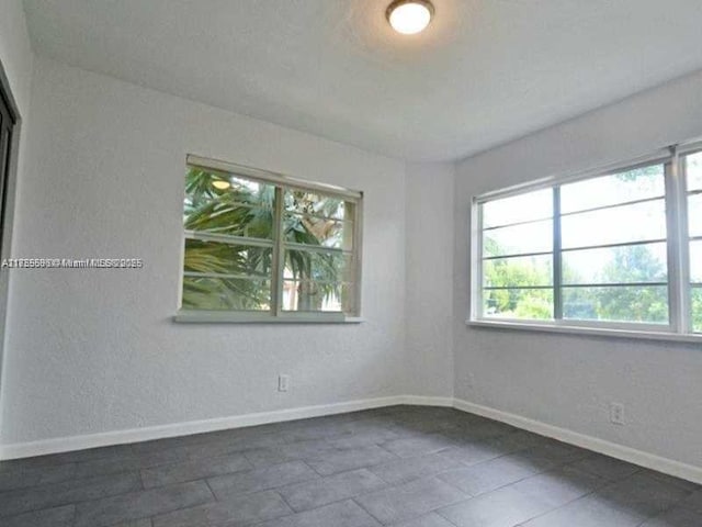 unfurnished room with baseboards