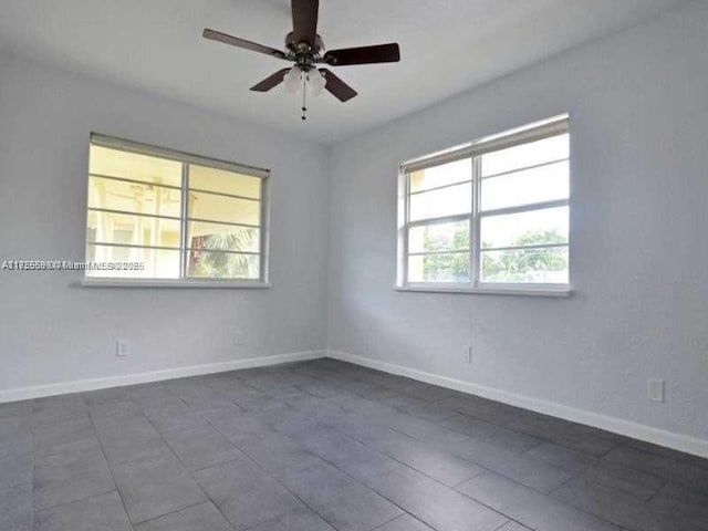 unfurnished room featuring ceiling fan and baseboards