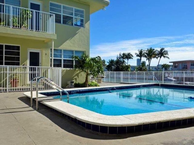 pool with a patio and fence