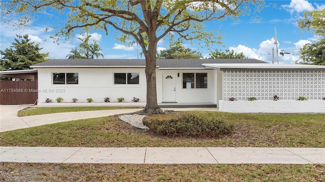 ranch-style house with an attached carport, driveway, a front lawn, and stucco siding