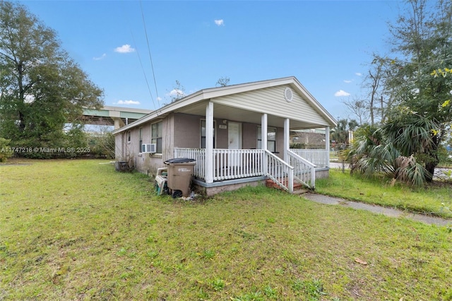 view of front of property with cooling unit, covered porch, and a front lawn