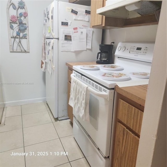 10004 Twin Lakes Dr Unit 36-F, Coral Springs, FL 33071 - kitchen with light tile patterned floors, brown cabinets, light countertops, under cabinet range hood, and white range with electric cooktop