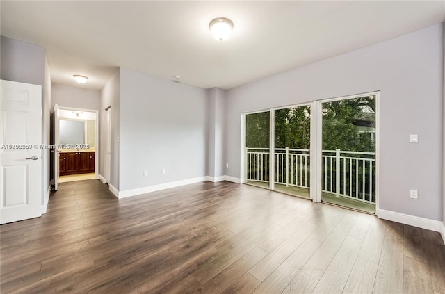 spare room featuring dark wood finished floors and baseboards