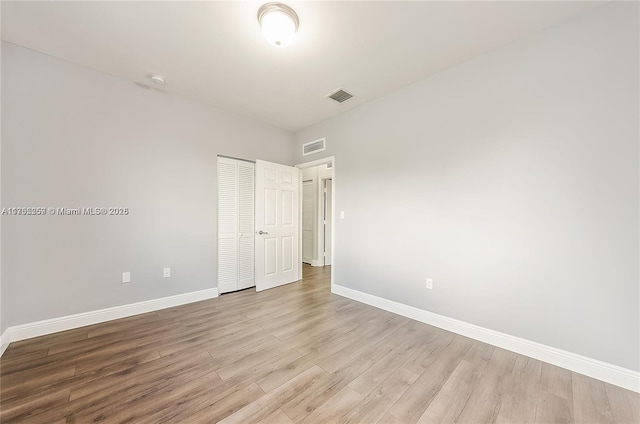 unfurnished bedroom featuring light wood-type flooring, visible vents, and baseboards