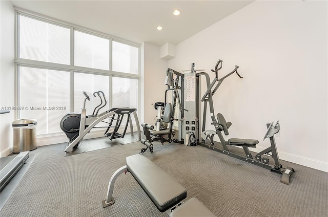 workout area featuring a wall of windows, recessed lighting, and baseboards