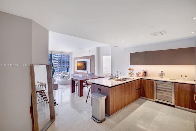 88 SW 7th St Unit 3003, Miami, FL 33130 - kitchen featuring wine cooler, a sink, a peninsula, modern cabinets, and visible vents