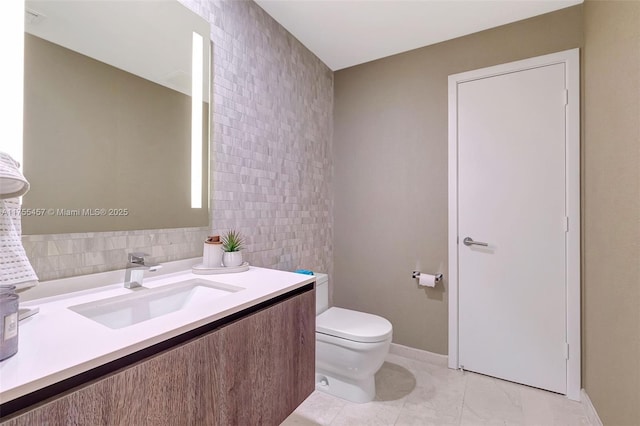 bathroom featuring toilet, tile walls, and vanity