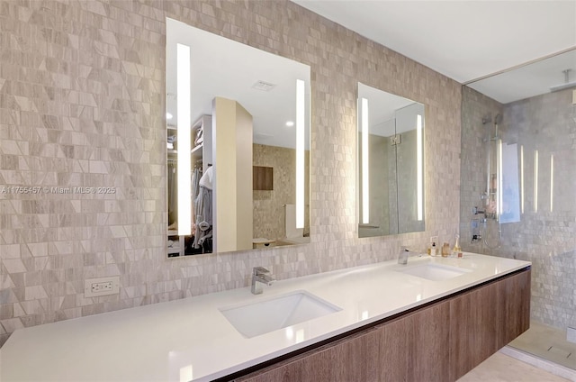 bathroom with double vanity, tile walls, and a sink