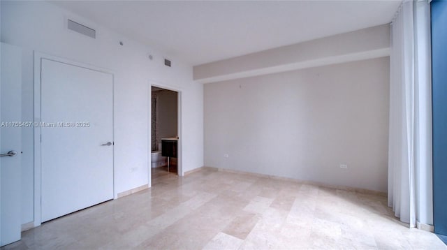 unfurnished room with baseboards and visible vents