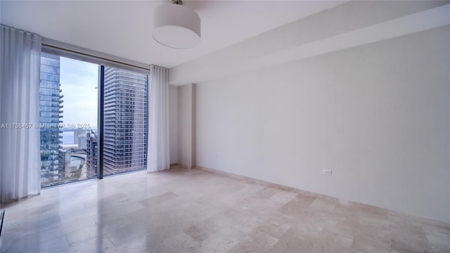 unfurnished room with a wall of windows and a city view