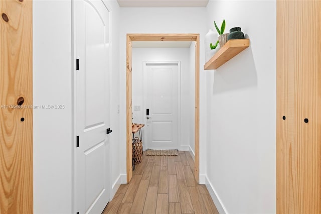 hallway with baseboards and light wood finished floors