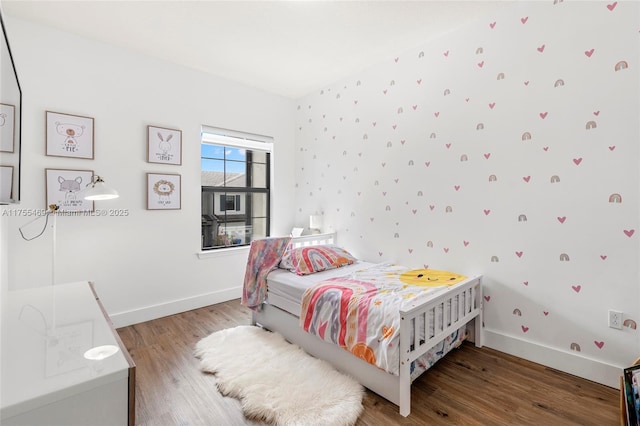 bedroom featuring baseboards and wood finished floors