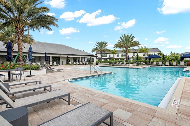 community pool with a patio and fence