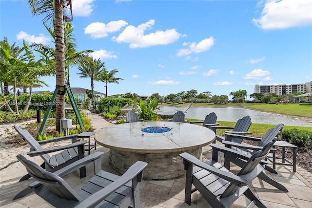 view of patio featuring a water view, a fire pit, and outdoor dining area