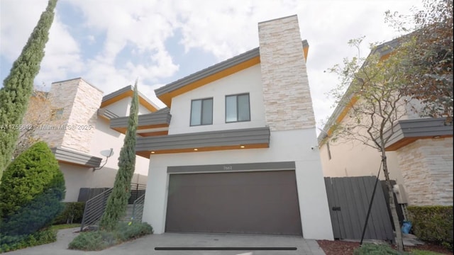 modern home with driveway, a garage, and stucco siding