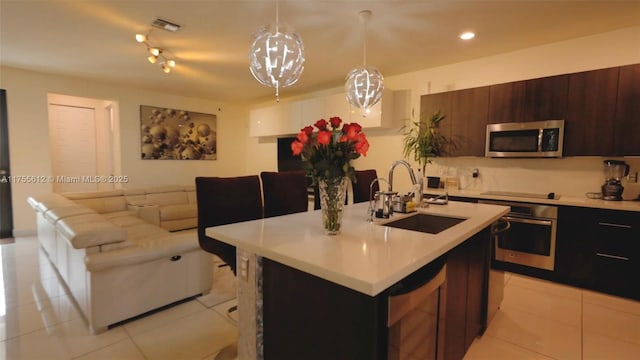 kitchen featuring light tile patterned floors, stainless steel appliances, light countertops, visible vents, and a sink