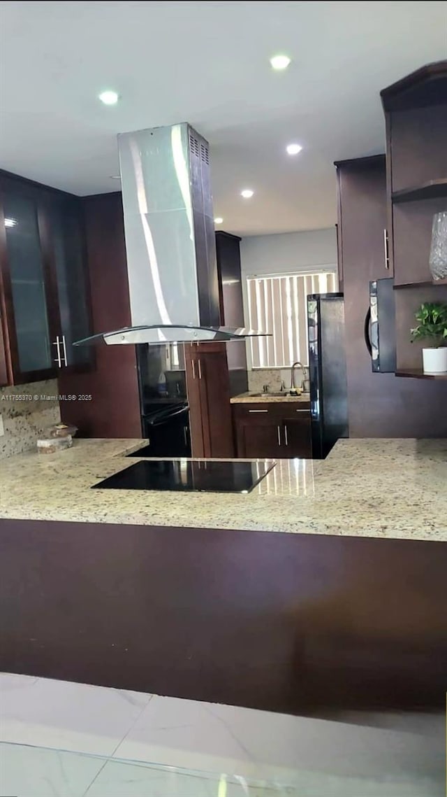 kitchen with light stone counters, recessed lighting, black appliances, and island range hood