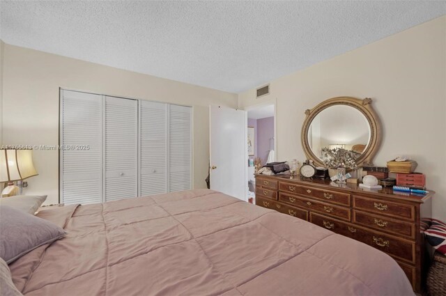 bedroom with visible vents, a textured ceiling, and a closet