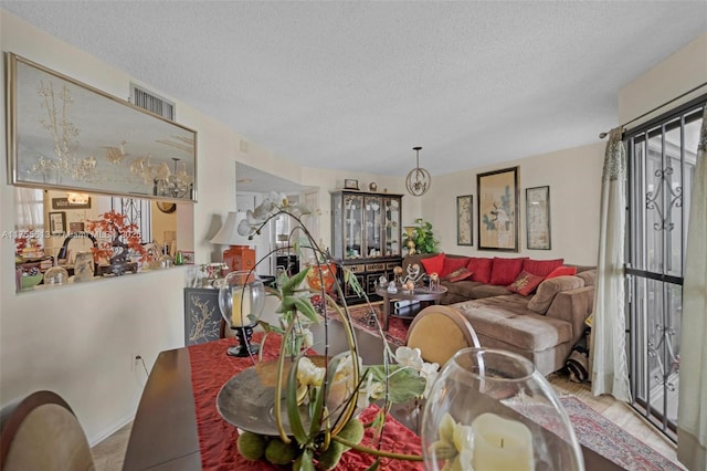 dining space with plenty of natural light, visible vents, and a textured ceiling