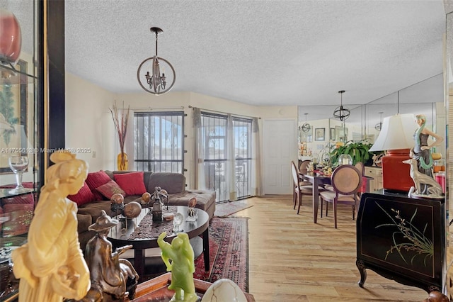 living room featuring a textured ceiling, an inviting chandelier, and wood finished floors