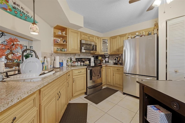 kitchen featuring open shelves, a sink, appliances with stainless steel finishes, light tile patterned flooring, and decorative backsplash