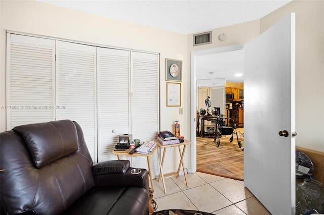 living area with light tile patterned floors and visible vents