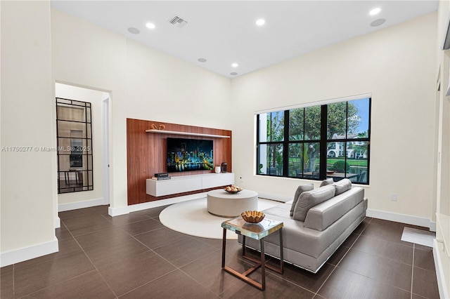 living area featuring tile patterned flooring, visible vents, baseboards, and recessed lighting