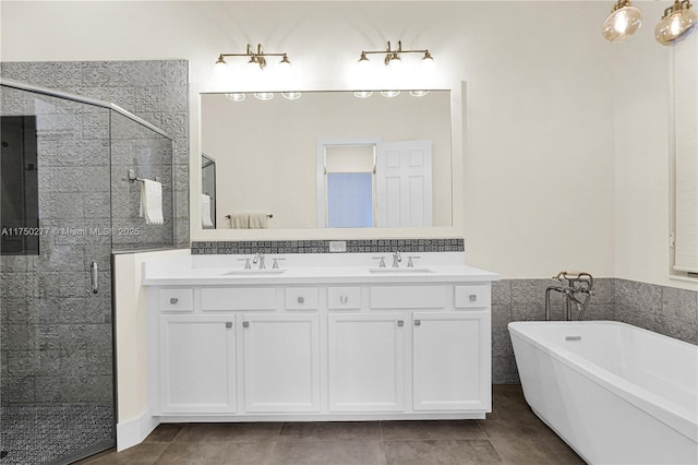 full bathroom featuring a stall shower, a sink, a freestanding bath, and double vanity