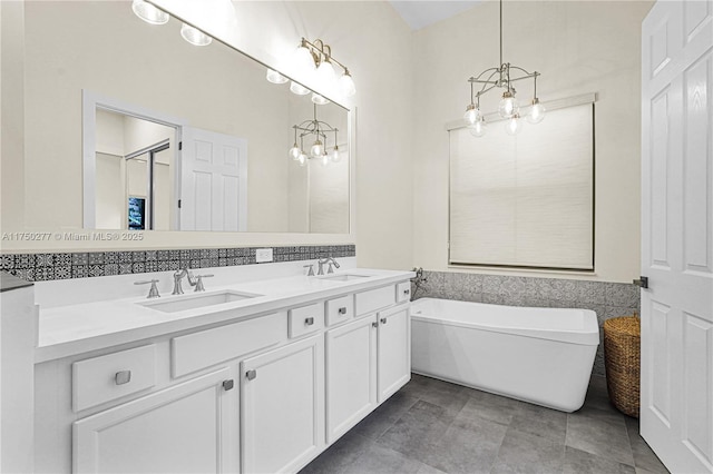 full bathroom with a soaking tub, a sink, and a notable chandelier