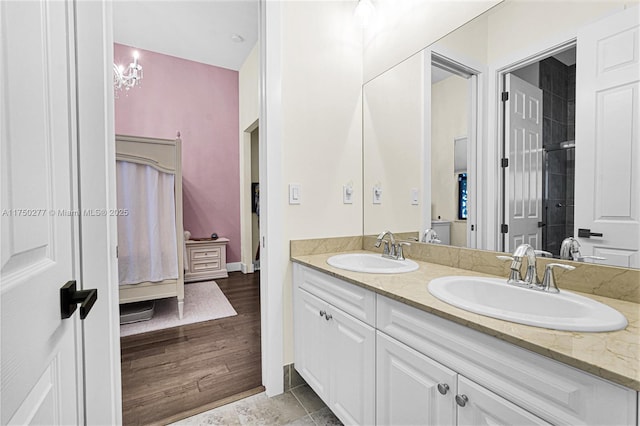 full bath featuring wood finished floors, a sink, ensuite bath, and double vanity