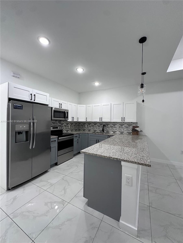 kitchen featuring light stone counters, marble finish floor, backsplash, appliances with stainless steel finishes, and a peninsula