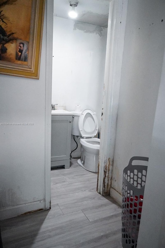 bathroom featuring toilet, wood finished floors, and vanity