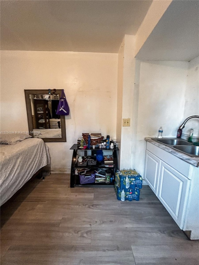 bedroom with a sink and wood finished floors