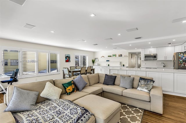 living area with wood finished floors, visible vents, and recessed lighting