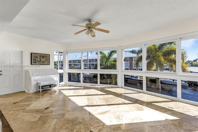 sunroom / solarium featuring a ceiling fan