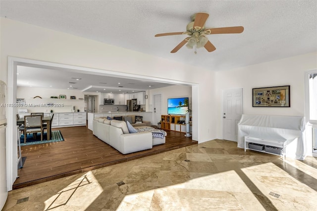 living room with a textured ceiling and wood finished floors