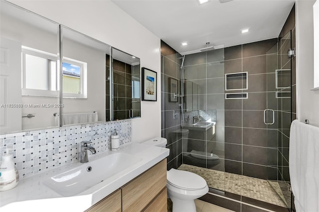 full bath featuring vanity, tasteful backsplash, a shower stall, and toilet