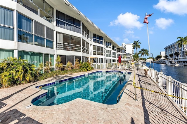 pool with a patio area and a water view