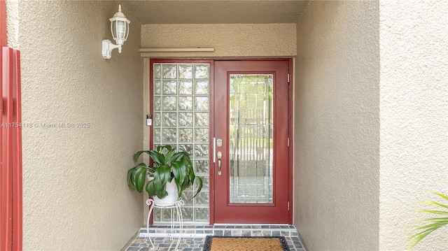 doorway to property featuring stucco siding